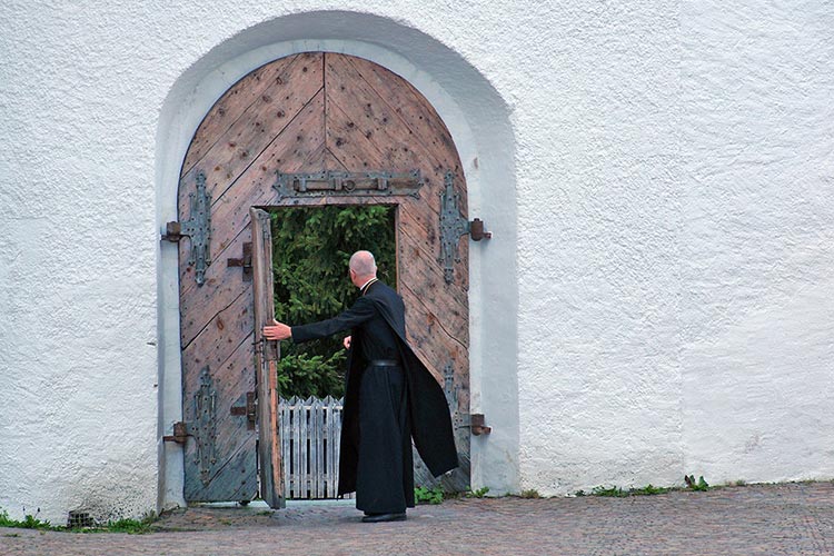 Anciano religioso abriendo una puerta